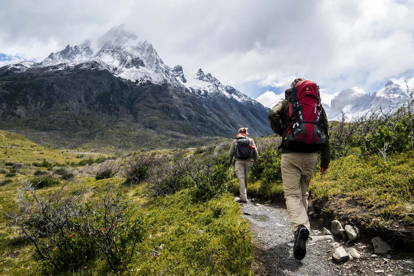 Walkers carrying backpacks along a mountain trail