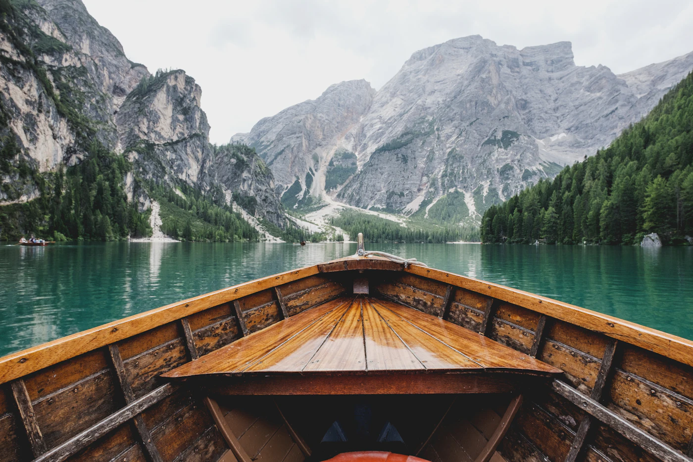 A wooden boat on a lake surrounded by mountains